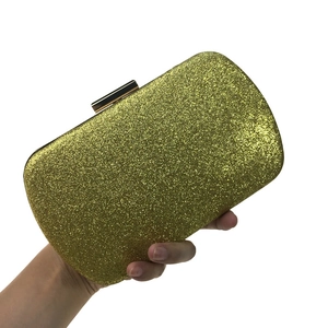 Macro shot of gold glitter evening clutch bag with metallic clasp and hard shell case