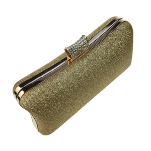 Macro detail of golden glitter clutch with sparkling rhinestones and metal closure