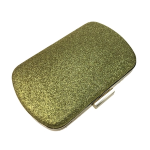 Close-up of golden glitter sequins on a square evening clutch with silver metal frame