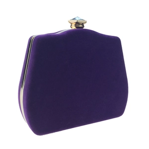 Detailed view of luxury purple velvet evening clutch with gold metal frame and gemstone