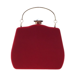 Detail of red velvet evening clutch featuring gold ring handle and faceted gem closure