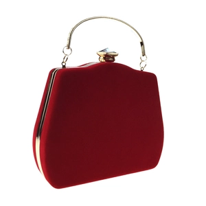 Detail of red velvet evening clutch with gold metal frame and sparkling crystal clasp
