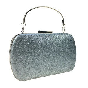 Macro detail of silver glitter evening bag with gold metal ring handle and hard shell frame