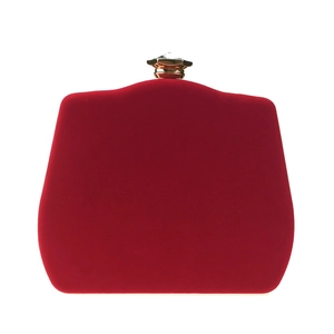 Detail of red velvet evening clutch with golden crystal clasp for formal wear