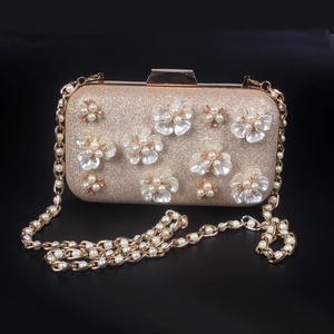 Détail macro du sac de soirée doré avec fleurs en perles 3D et cristaux scintillants