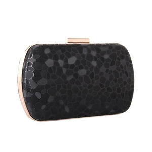 Detailed view of black clutch with geometric stone texture and gold-tone metal frame