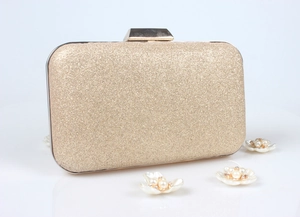 Détail de la pochette de soirée à paillettes dorées avec d'élégantes fleurs perlées
