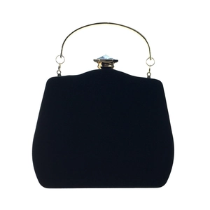 Detailed view of black velvet evening bag with gold handle and blue-gray gemstone
