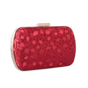 Detail of red water cube textured leather clutch with gold metal frame and clasp