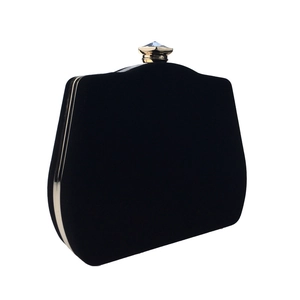 Detail of black velvet gourd evening clutch featuring a gold metal frame and crystal clasp
