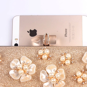 Detailed size comparison of a glitter party clutch with pearls and a rose gold phone