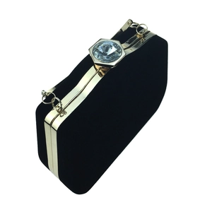 Detail of black velvet gourd evening clutch with gold trim and crystal hexagonal clasp