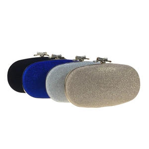 Detail of four colorful oval evening clutches with crystal bow clasps on white background