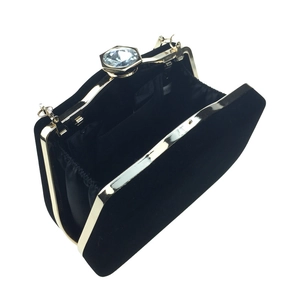 Detailed interior of black velvet evening clutch showing metal frame and fabric lining