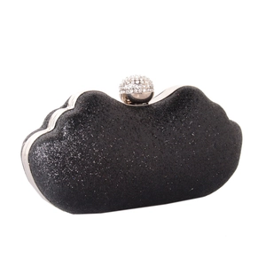 Detailed view of black glitter evening clutch featuring a sparkling rhinestone ball clasp