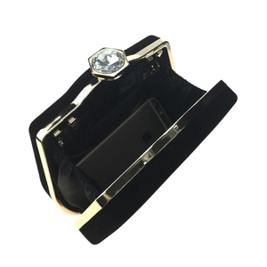 Detail view of black velvet evening bag showing inner space and large crystal clasp