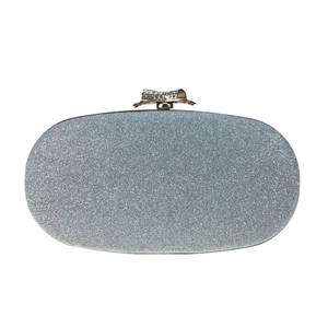 Detail of silver glitter evening clutch bag with sparkling rhinestone bow clasp closure