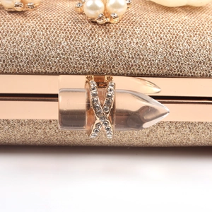 Close-up of glitter evening bag with pearl floral cluster and rhinestone clasp detail