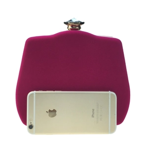 Macro detail of rose red velvet evening clutch featuring a faceted gemstone metal clasp