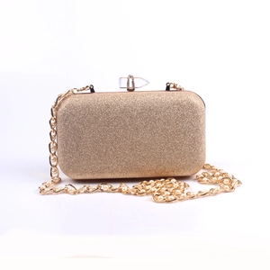 Detail of gold glitter clutch with pearl metal chain and crystal top clasp