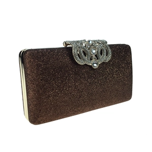 Detail of a brown glitter evening clutch featuring a crystal-encrusted silver metal clasp