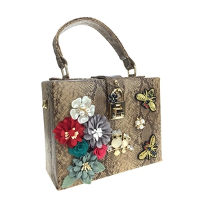 Détail du sac serpent avec fleurs 3D, broderie abeille et pendentif hibou étincelant