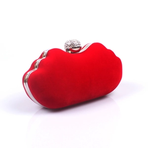 Close-up of red velvet clutch with silver metallic frame and sparkling crystal ball clasp