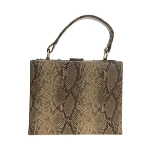 Détail du motif peau de serpent et ferrures dorées sur le sac à main structuré
