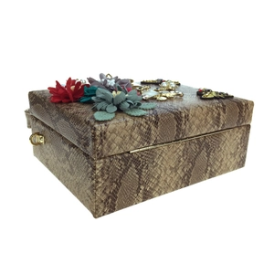 Détail du sac à main serpent avec fleurs en tissu 3D et abeilles en cristal