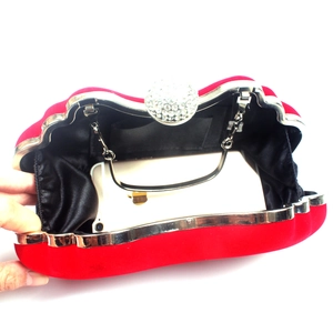 Red velvet evening bag showing internal capacity with phone and silver chain strap