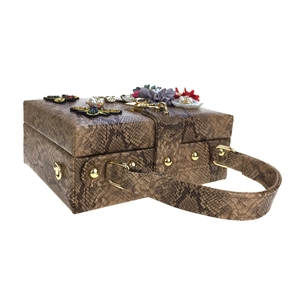Détail du sac à main en cuir serpent avec fleurs 3D et décorations d'insectes sertis