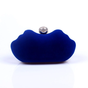 Close-up of a royal blue velvet evening clutch with a sparkling rhinestone-set ball clasp