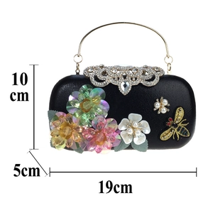 Macro view of floral sequin patterns and crystal closure on the black evening clutch bag