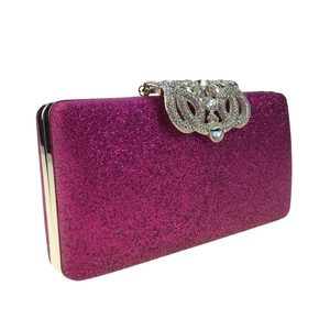 Detail of rose red sequin evening clutch bag with luxury crystal embellished gold clasp