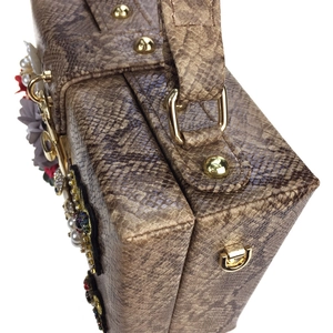 Détail d'un sac à main imitation serpent avec fleurs 3D, perles et boucles dorées