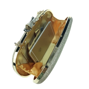 Interior view of gold glitter evening bag showing satin lining and smartphone capacity