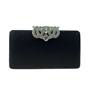 Close-up of crystal-encrusted crown metal clasp on a sparkling sequin clutch bag