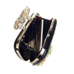 Interior view of black evening clutch showing capacity for a smartphone and gold chain