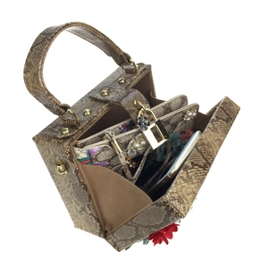 Vue détaillée des accents floraux et de la texture serpent d'un sac à main de luxe