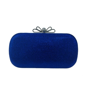 Détail d'une pochette de soirée bleu roi pailletée avec fermoir nœud en strass argenté