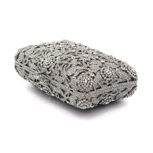 Close-up of luxury silver evening bag with hollow floral pattern and crystal rhinestones