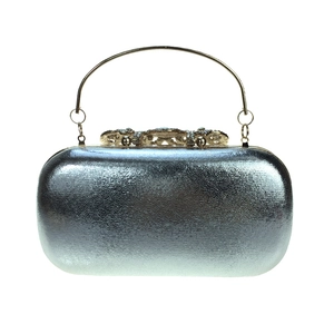 Detail of silver evening clutch bag with ornate gold floral clasp and crystal rhinestones