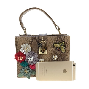 Détail du sac à imprimé serpent avec fleurs en relief, broderie abeille et échelle