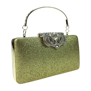 Detail of golden evening clutch bag featuring shimmering sequins and diamond encrusted clasp