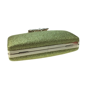 Close-up of golden sequin clutch bag showing side profile and metallic frame detail
