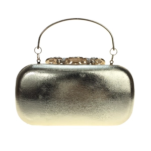 Detailed close-up of crystal-encrusted gold floral clasp and textured metal surface