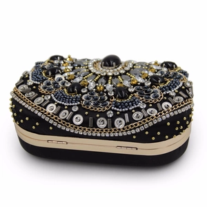 Detail of vintage evening bag with black rhinestones and gold chains close-up