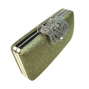 Detail of gold sequin clutch bag with crystal rhinestone clasp and metal frame