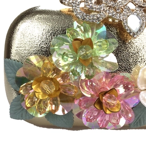 Close-up of three-dimensional sequin flowers and crystal detailing on the evening bag