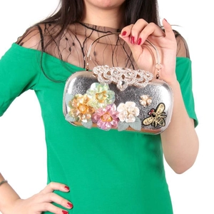 Detail of silver evening clutch with floral sequins, bee embroidery and gold handle